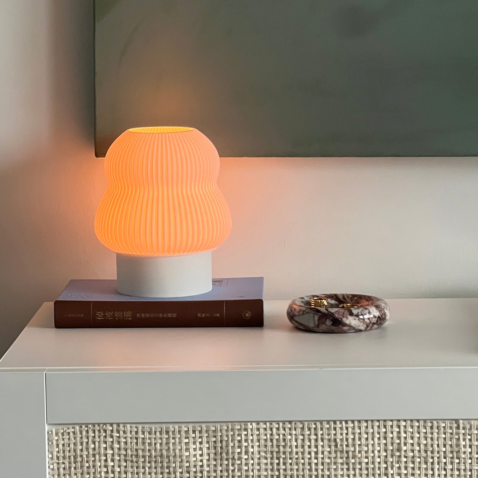 Small lamp with a textured shade on a surface, with a neutral background