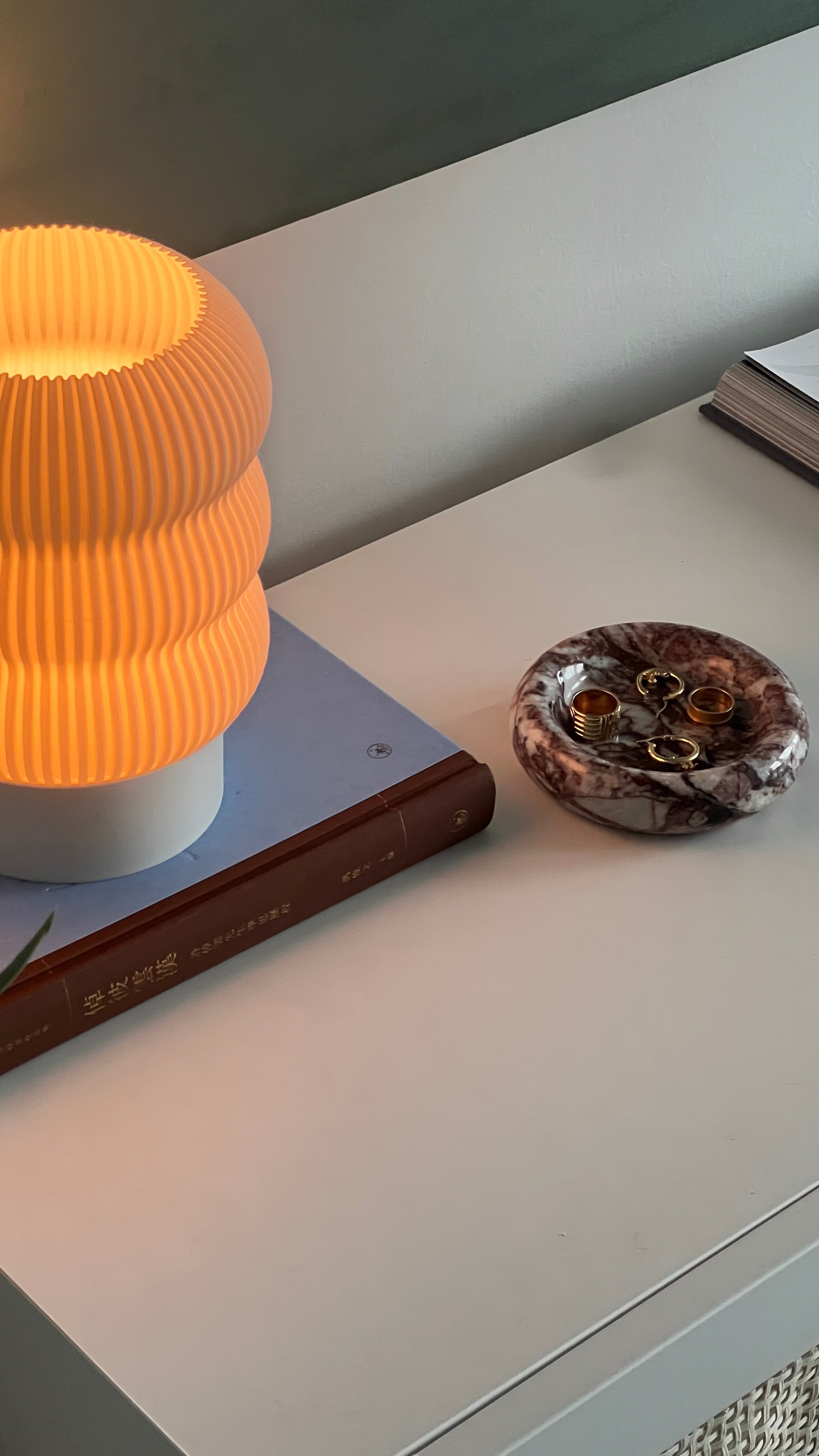 Lamp on a book with a decorative object on a surface