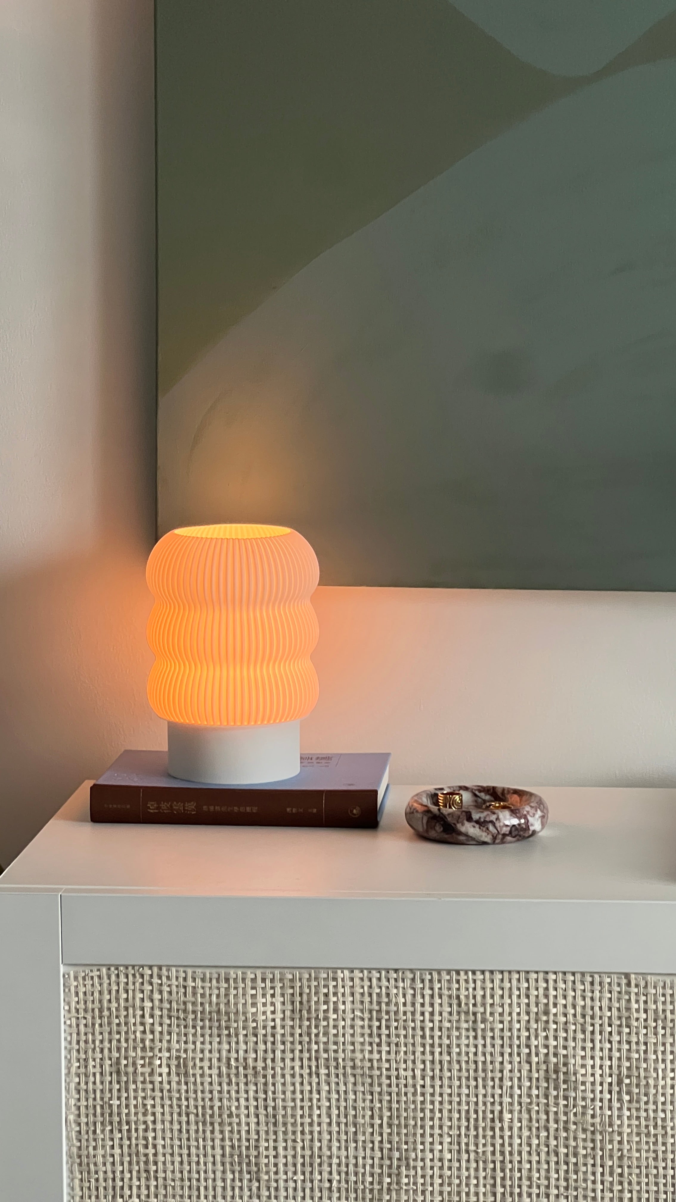 Table lamp with ribbed design on a white surface against a neutral wall