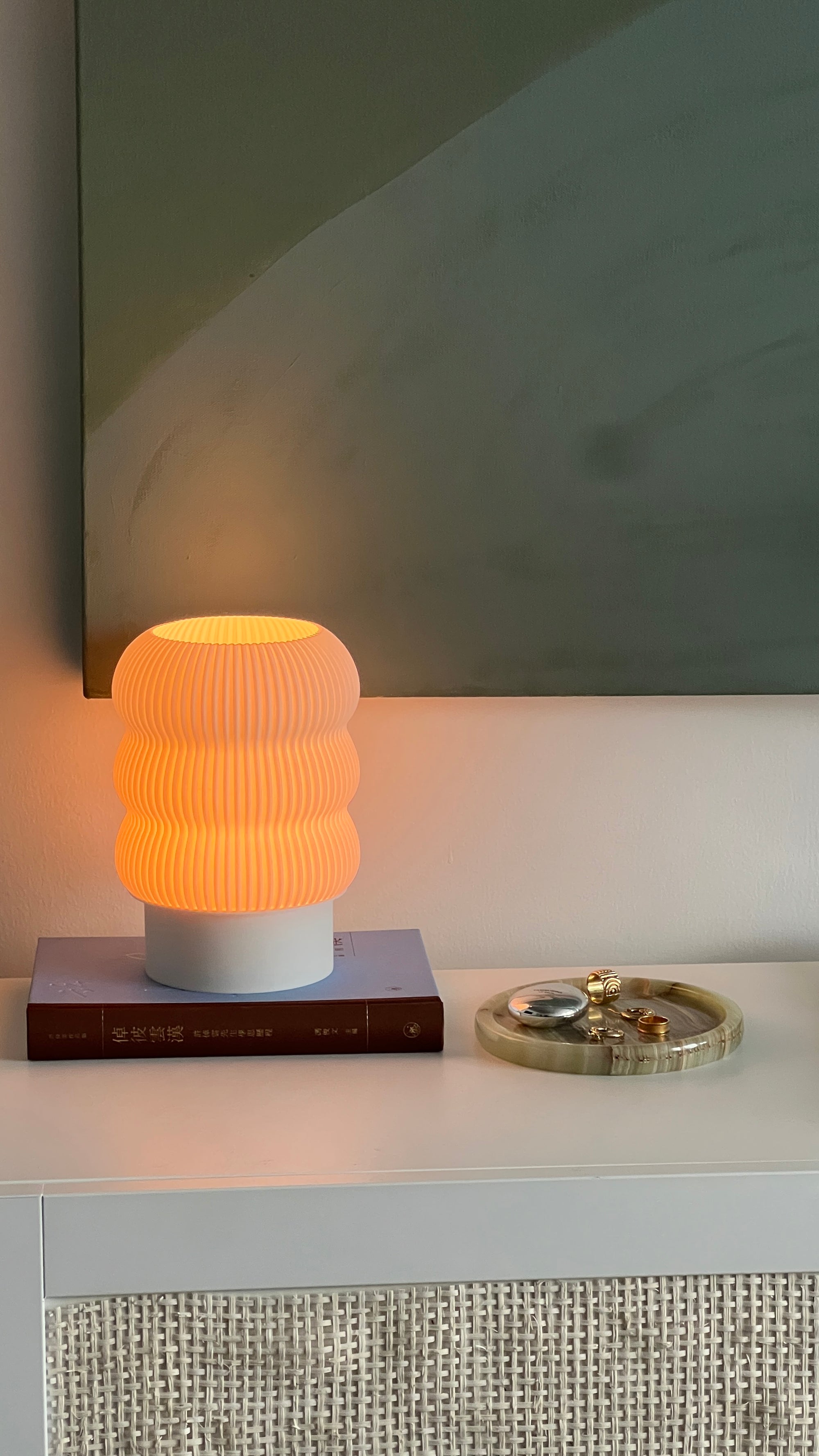 Table lamp with ribbed design on a white surface, with a blurred background