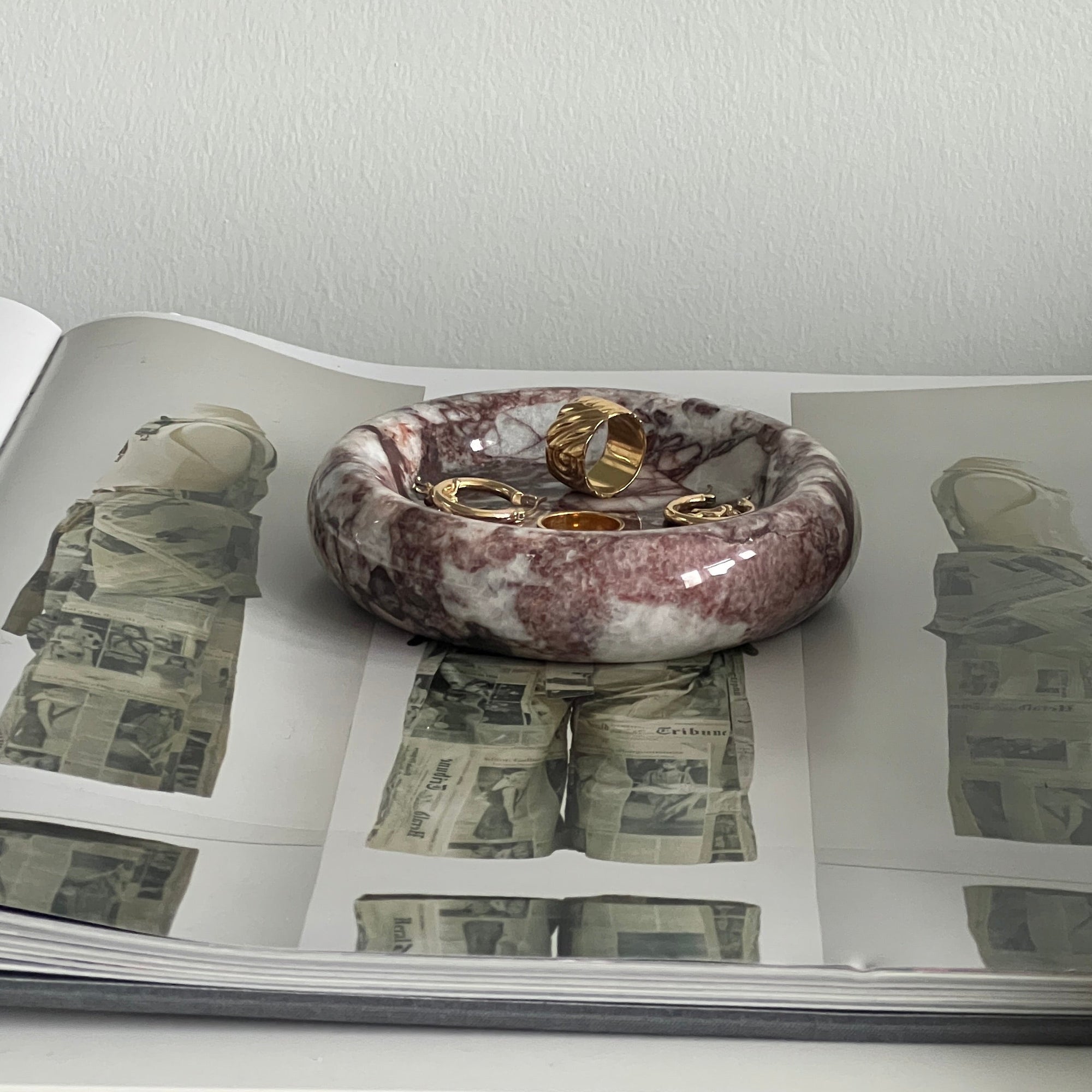 Decorative bowl with marbled design on a surface with printed images of money.