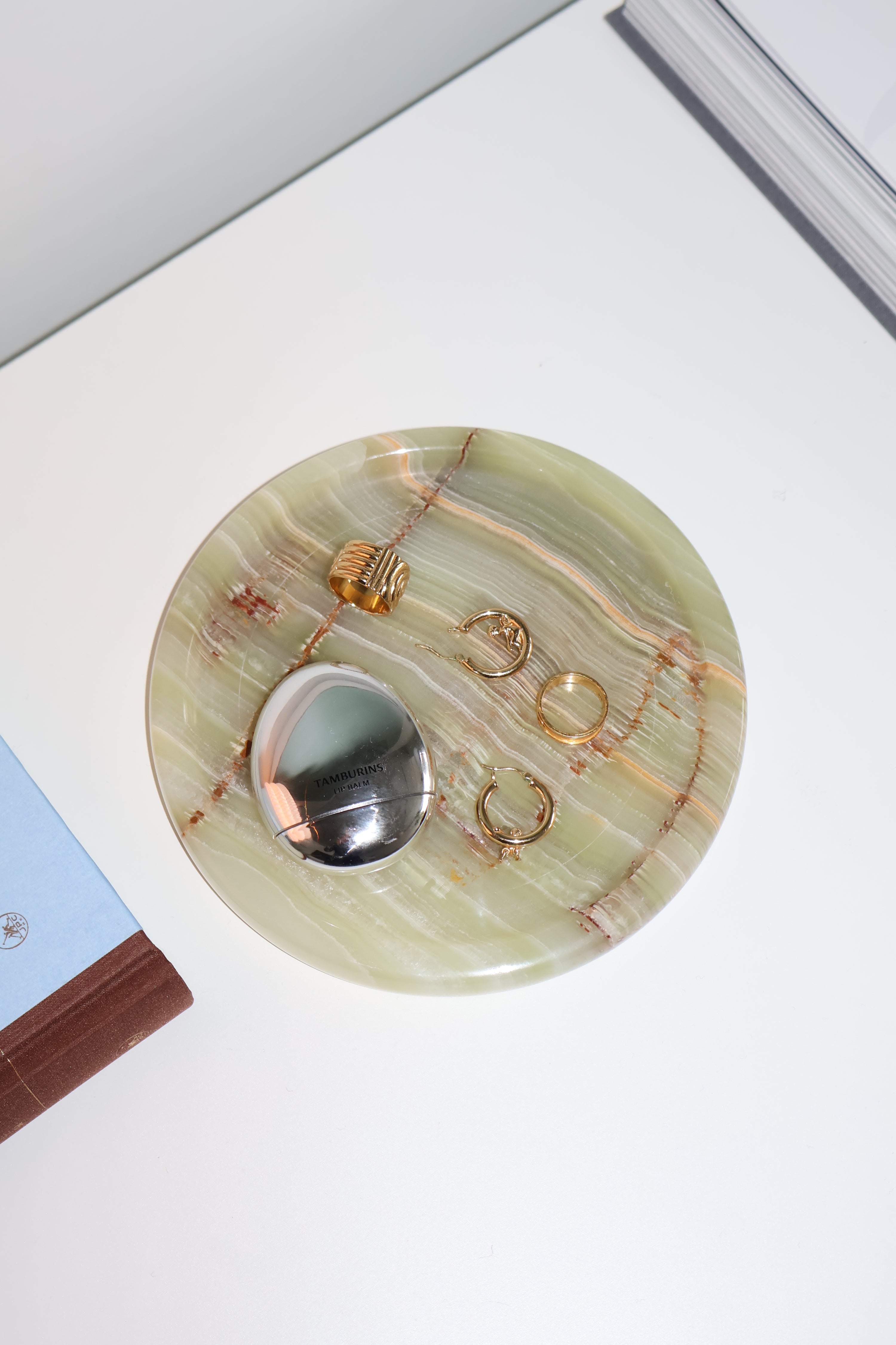 Jewelry set on a decorative stone platter with a white background