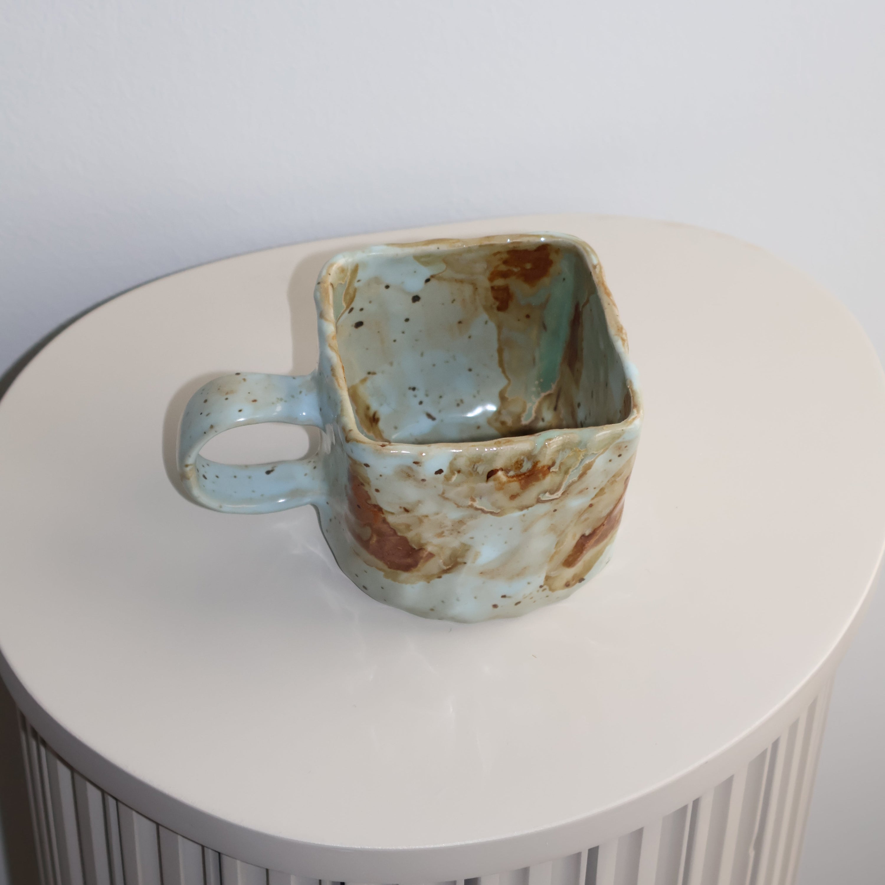 Ceramic cup with a textured surface on a white background