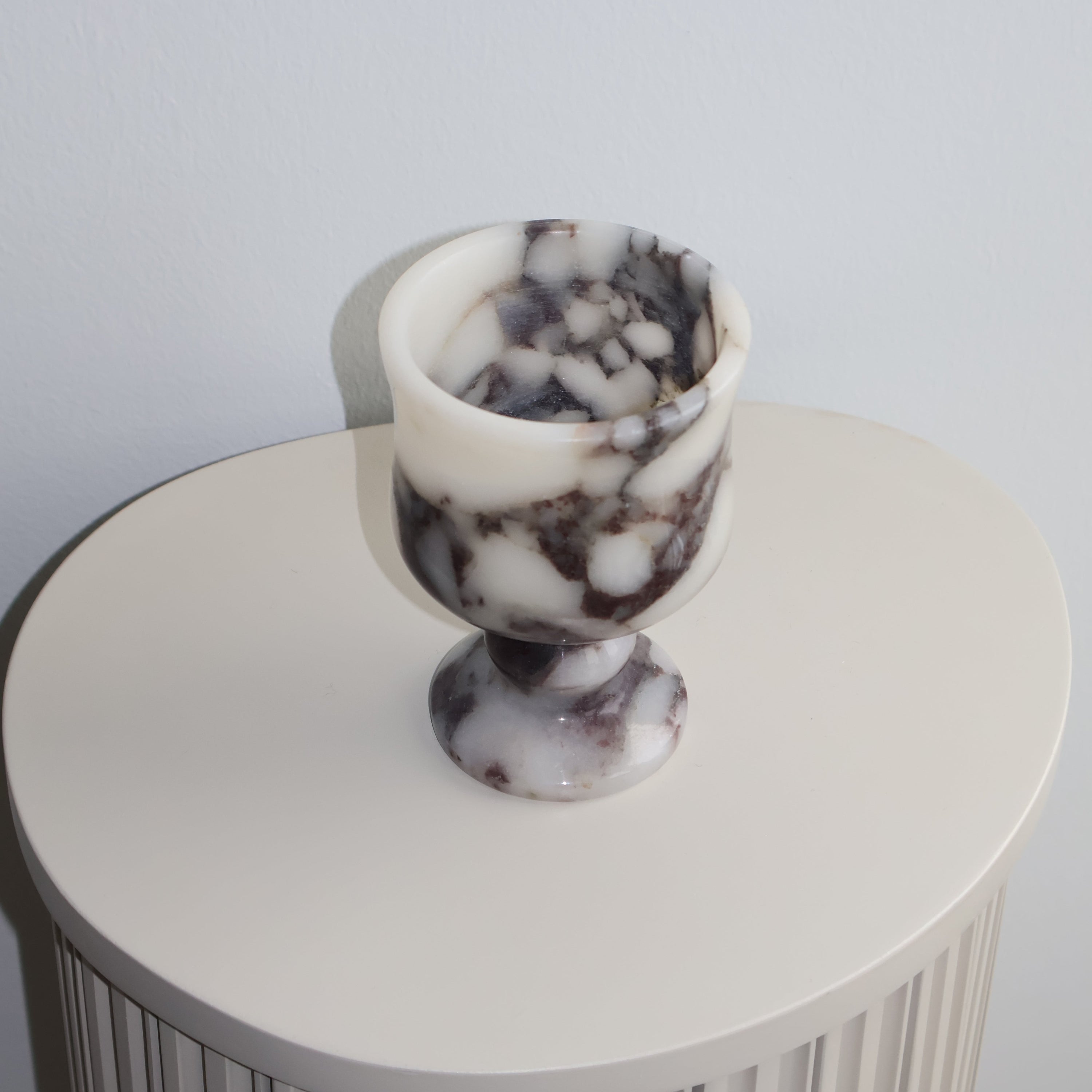 Decorative tea light holder with marble-textured top on a plain background