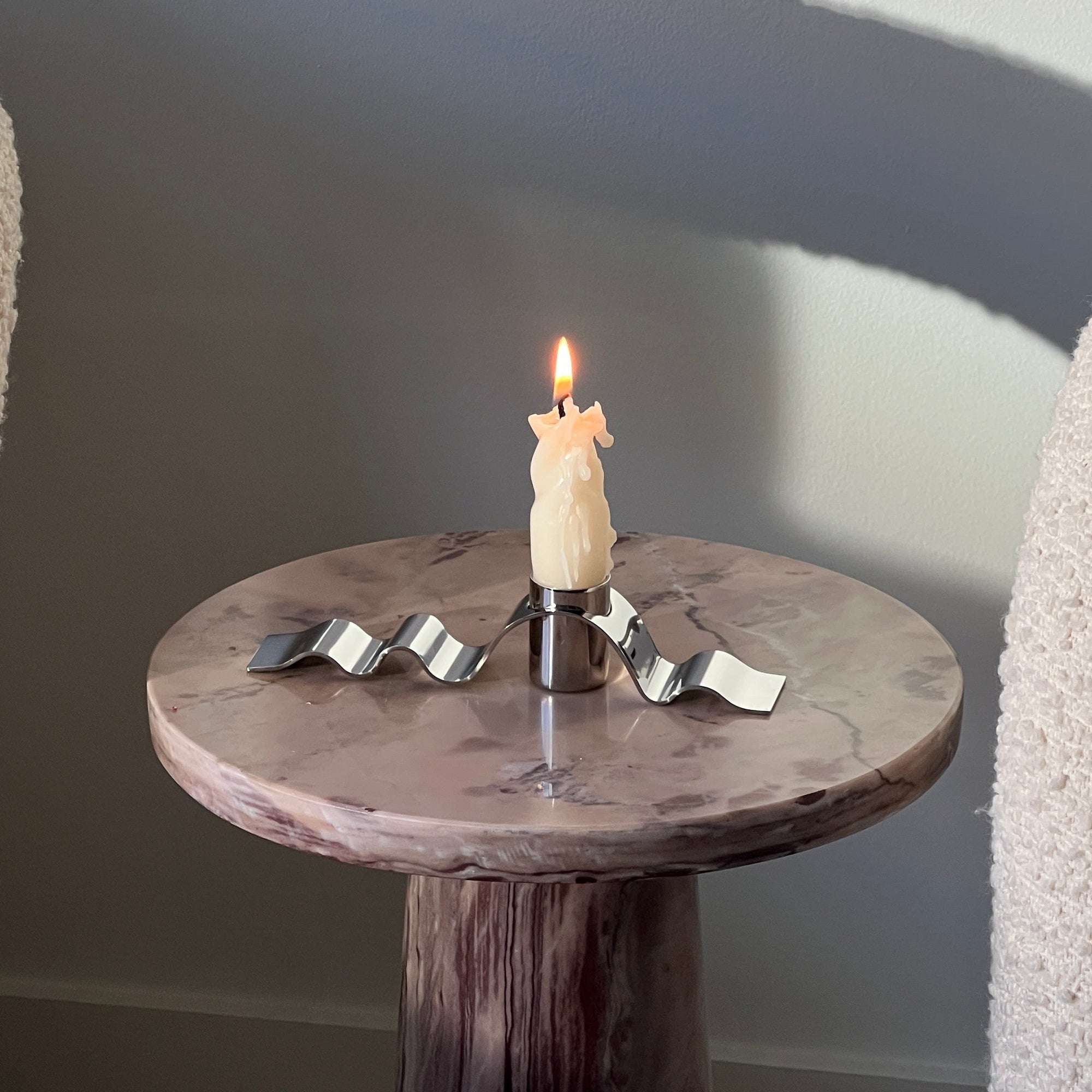 Small candle on a wooden table with a gray background