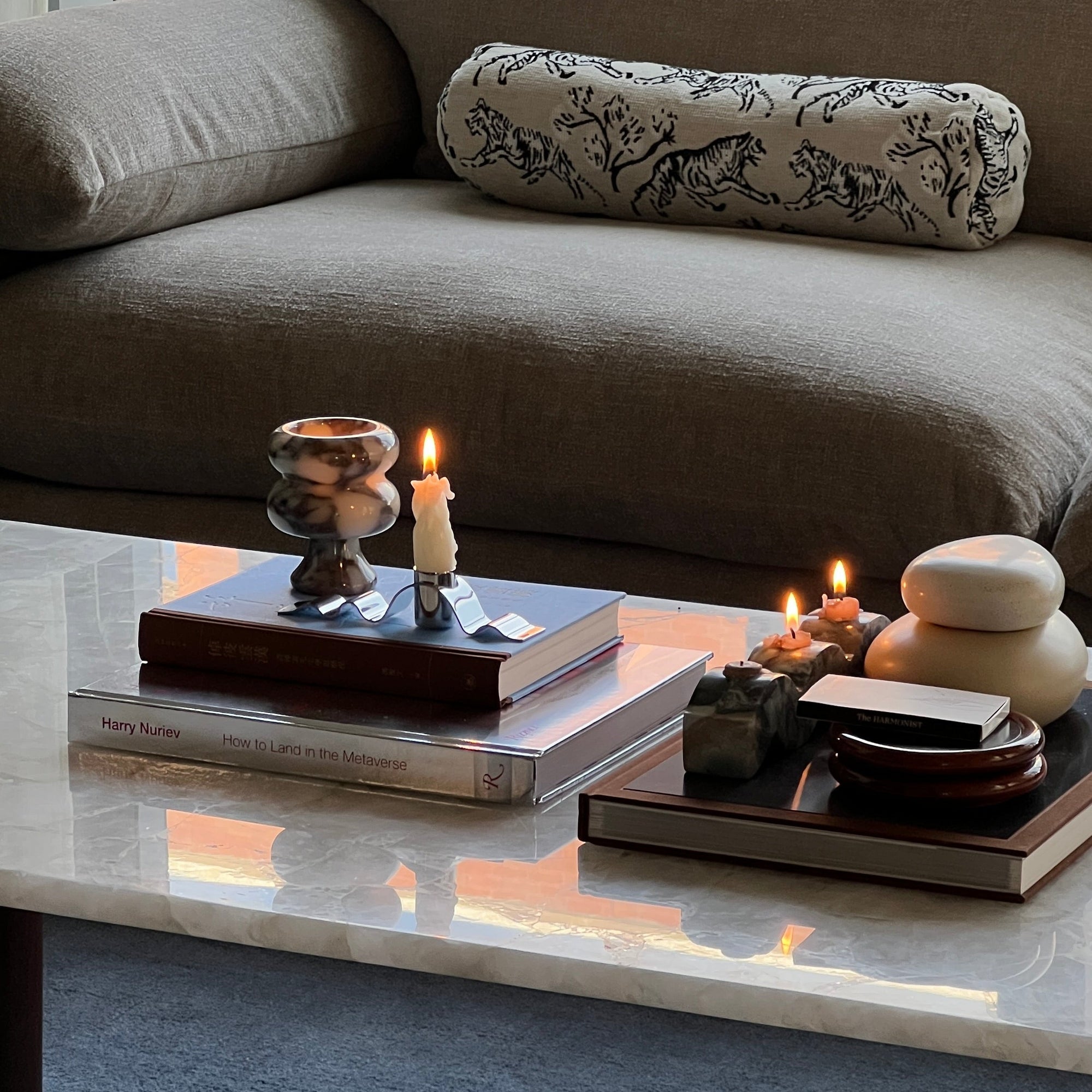 Modern living room with a gray sofa, coffee table, and decorative items.