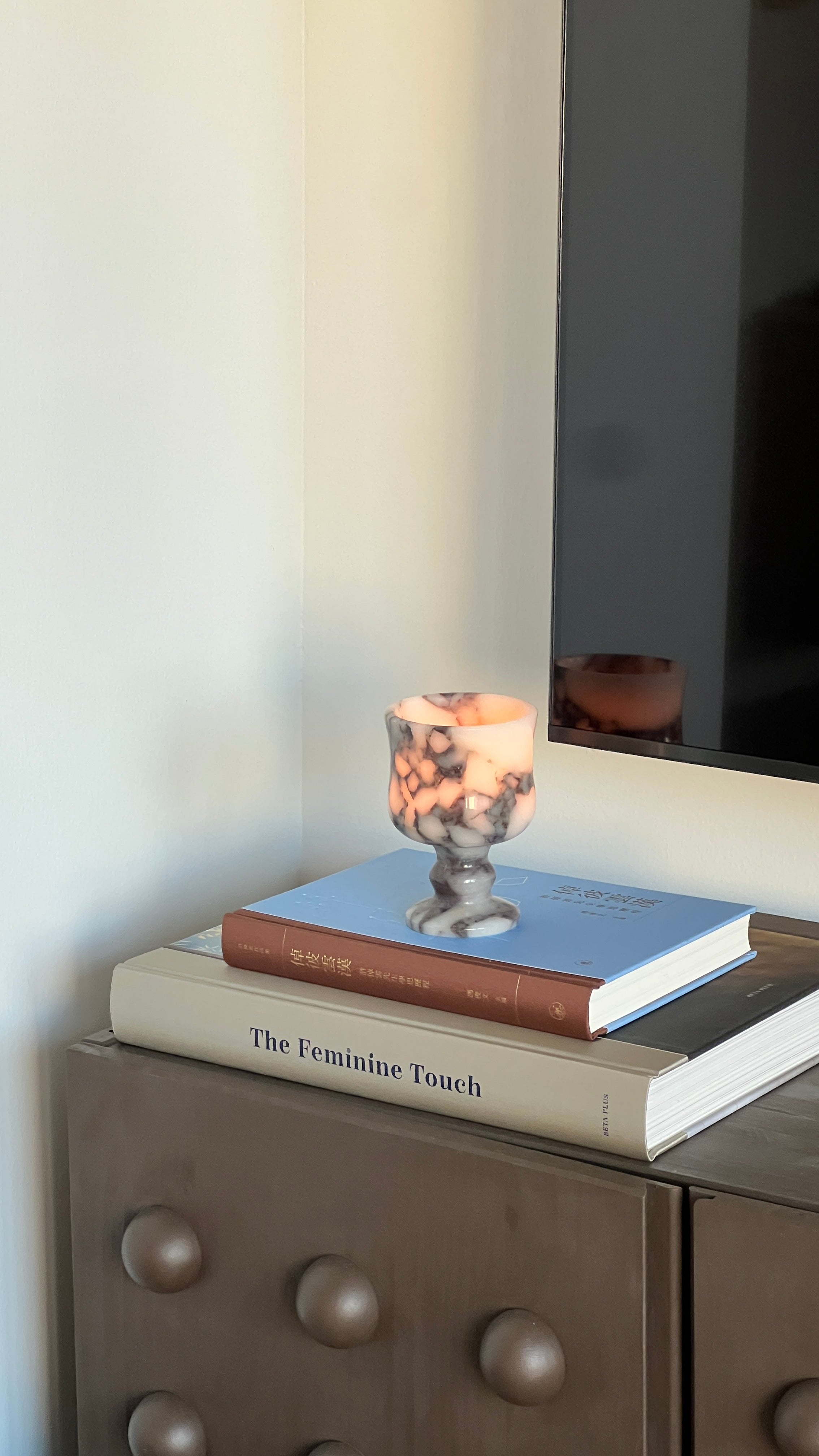 Candle in a holder on top of books with a blurred background