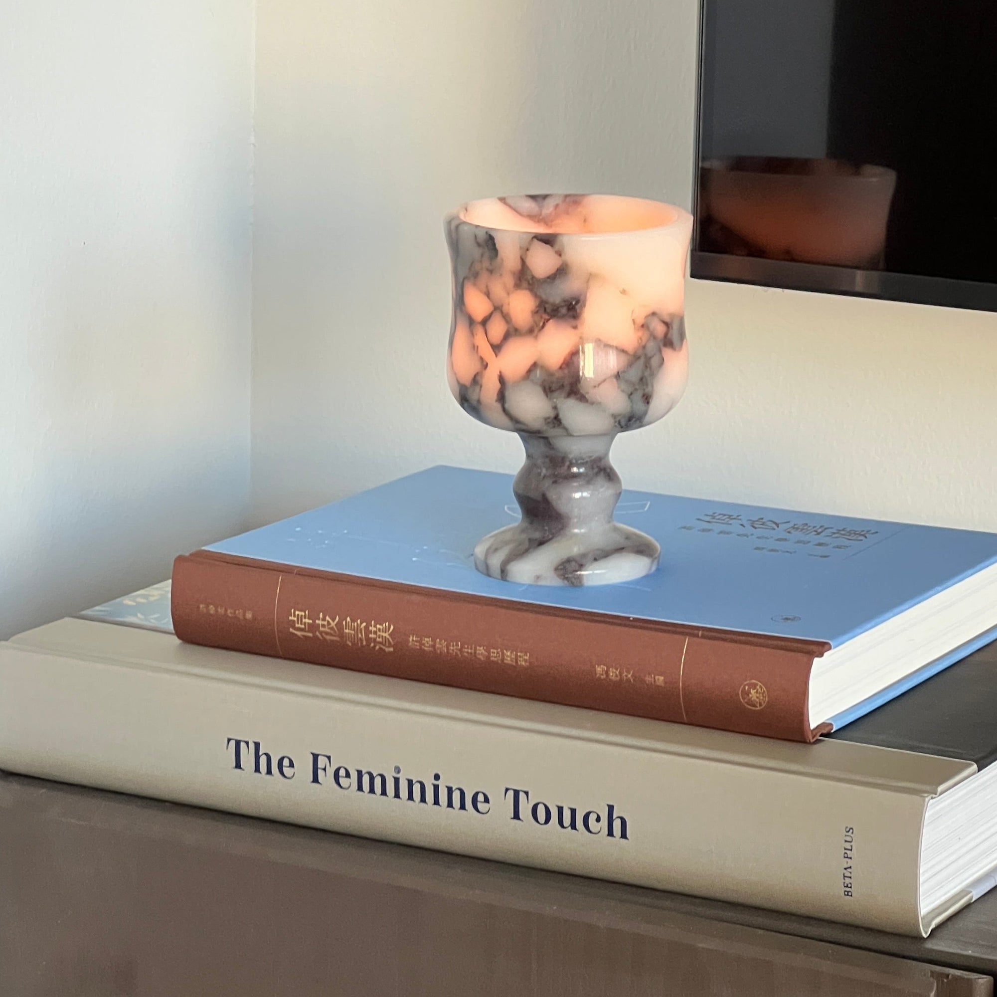 Candle on top of books with a blurred background