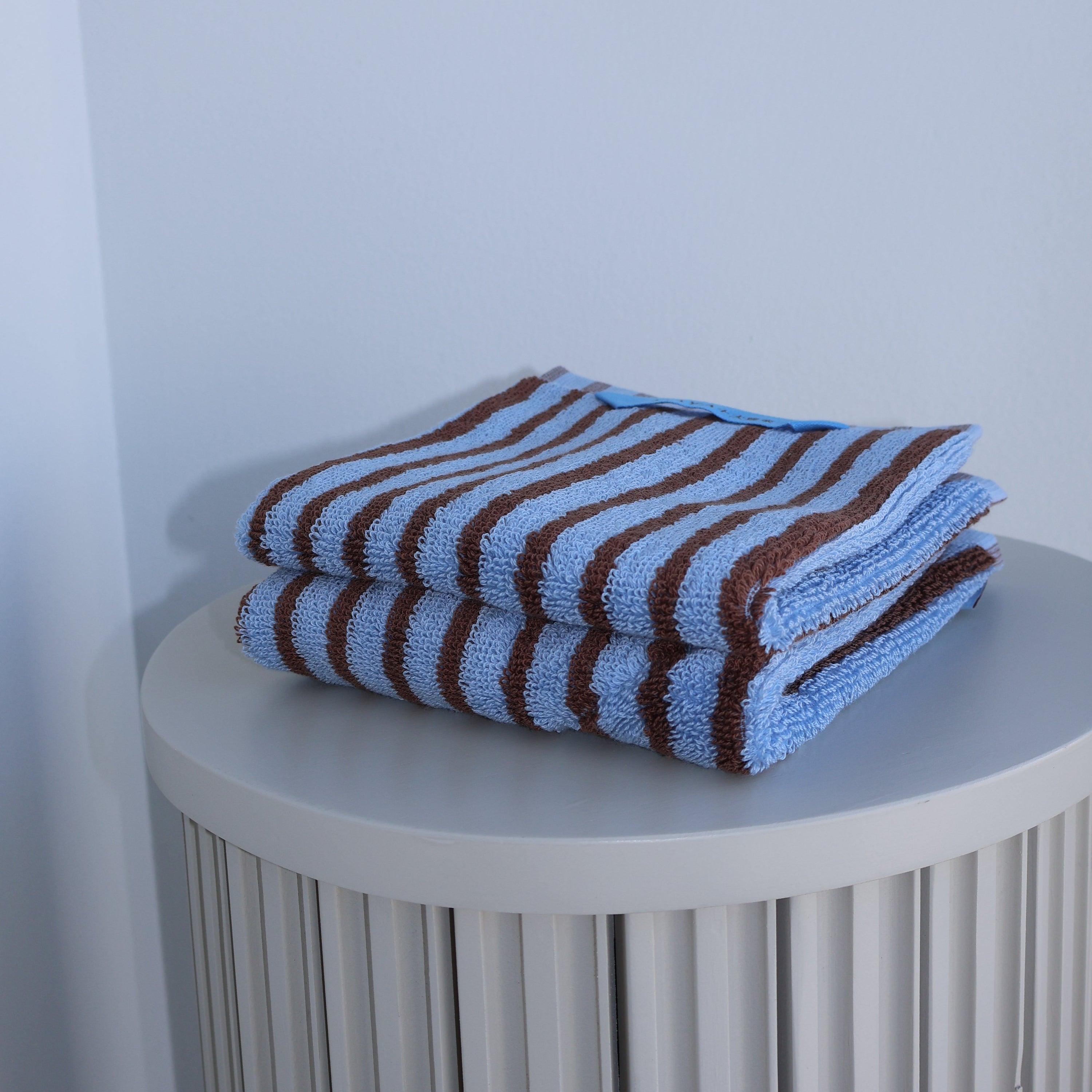 Striped washcloth on a cylindrical object with a white background