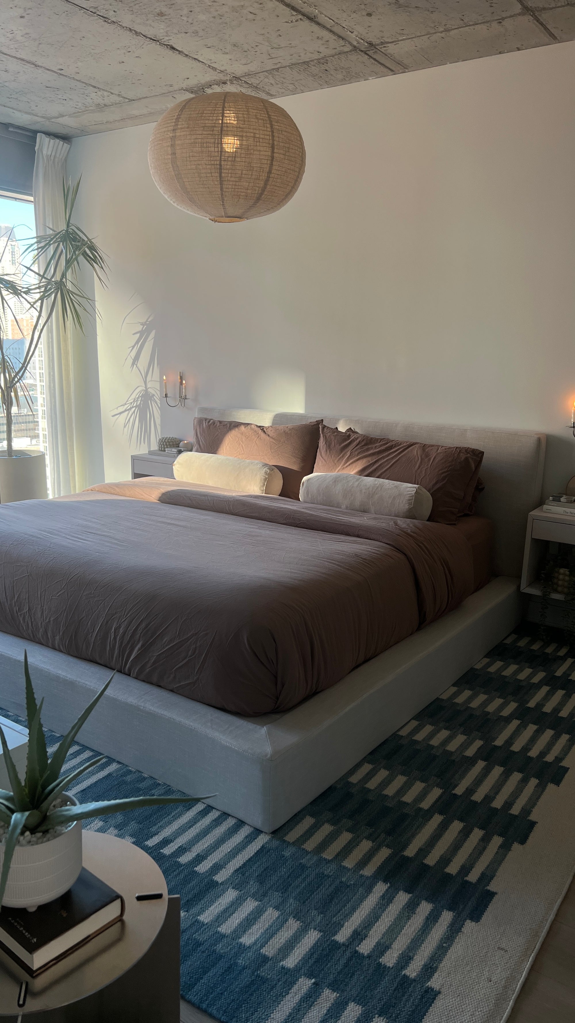 Modern bedroom with a bed, side tables, and decorative elements.