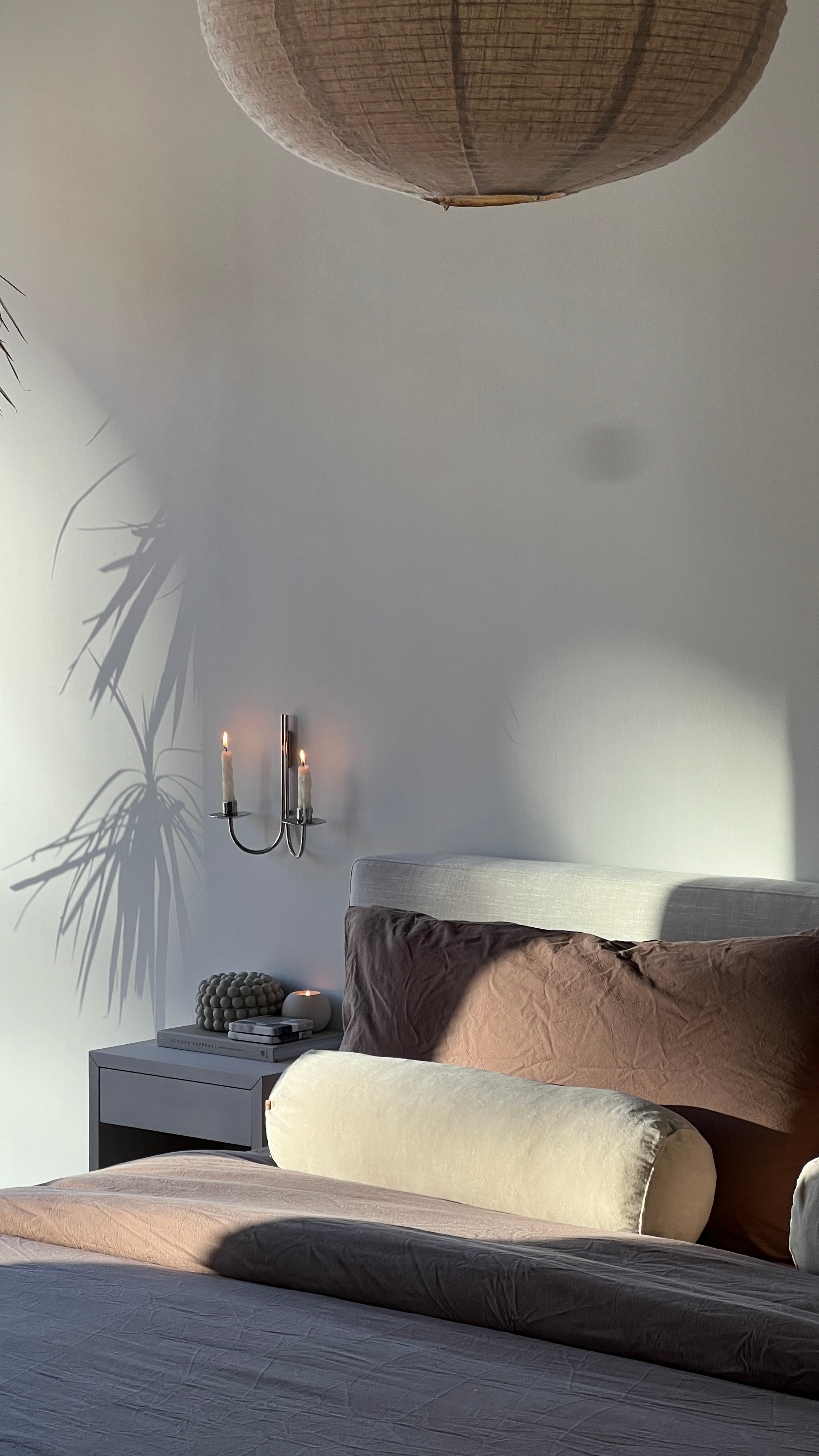 Bedroom with a bed, nightstand, and wall sconce.